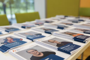 Broschüren zu den Kandidat:innen liegen auf einem Tisch.